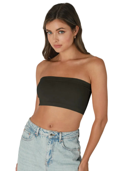 Woman wearing a black strapless top and light blue jeans on a gray background