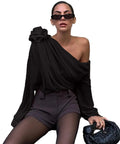 Woman wearing a black one-shoulder top and shorts.