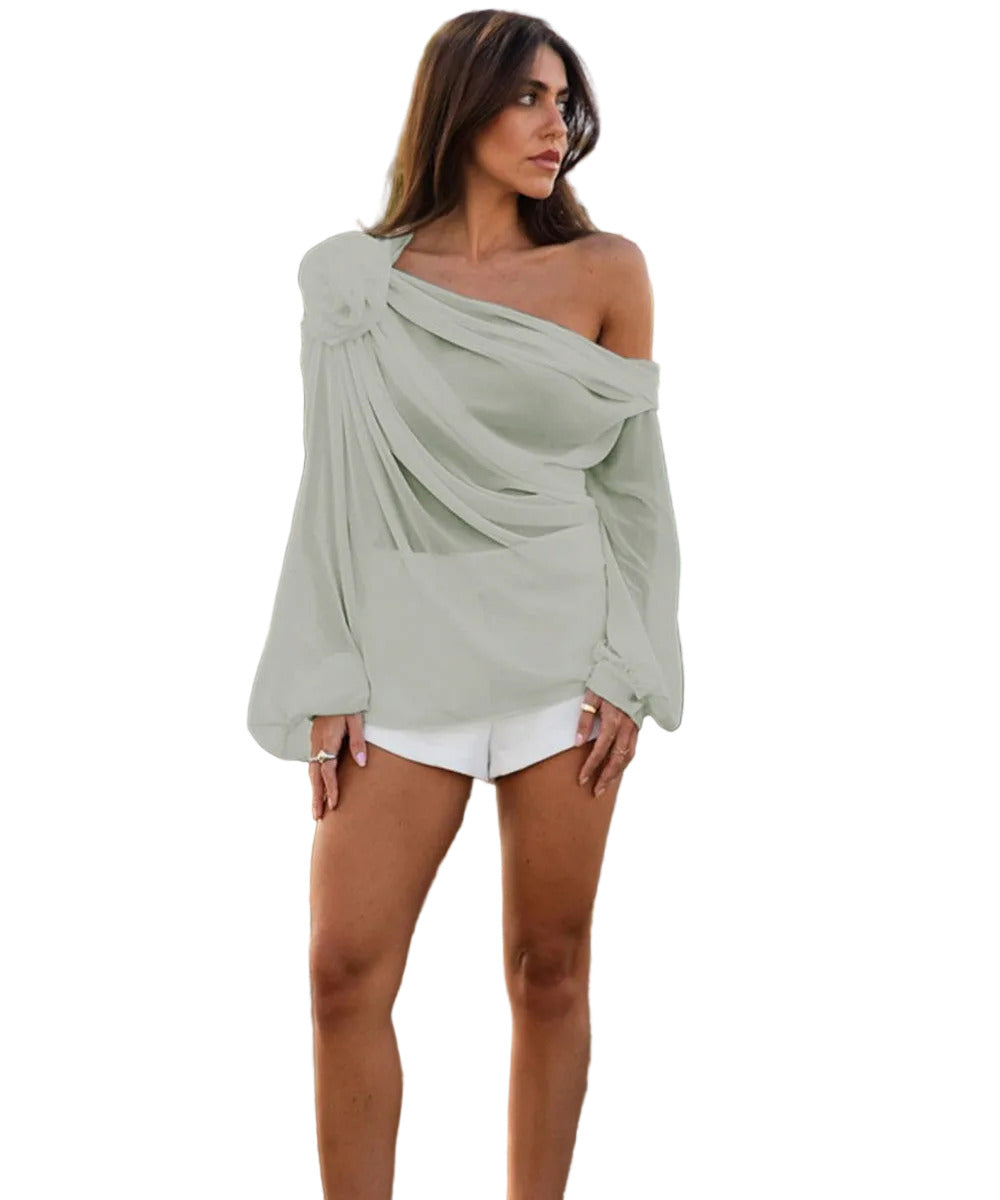 Woman wearing a light green off-shoulder top and white shorts.