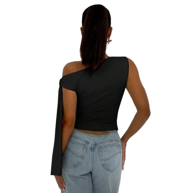 Person wearing a black one-shoulder top and light blue jeans against a white background