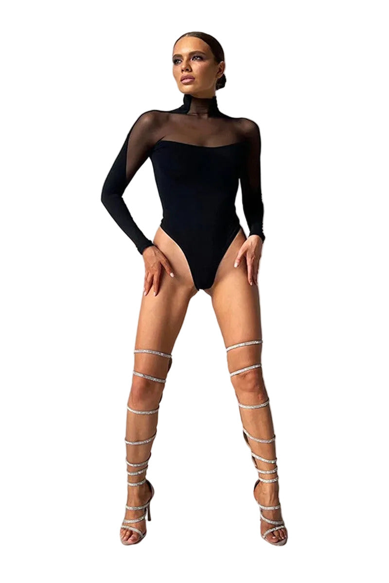 Model wearing a black bodysuit and sheer white sandals on a gray background