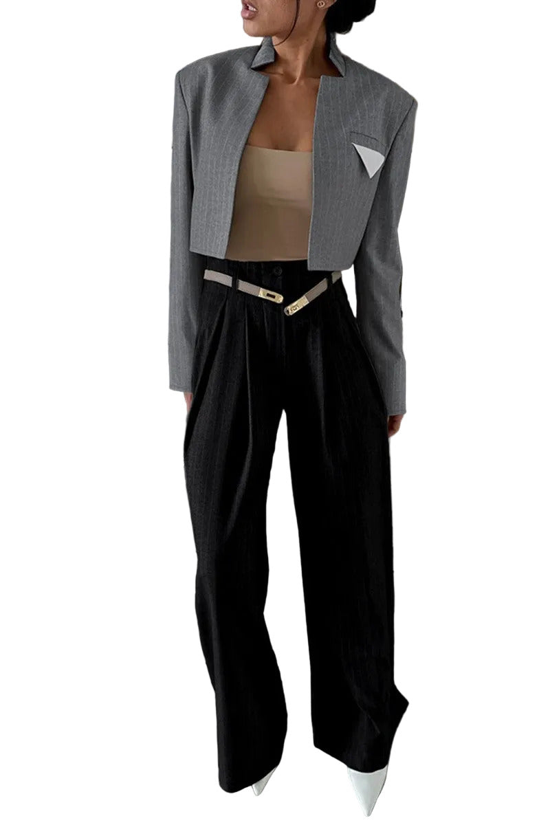 Person wearing a gray blazer, beige top, and black pants