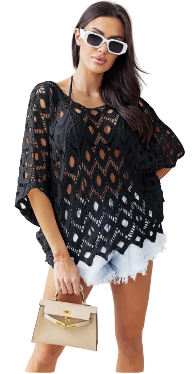 Woman wearing a black crochet cover-up with white sunglasses and a beige handbag.