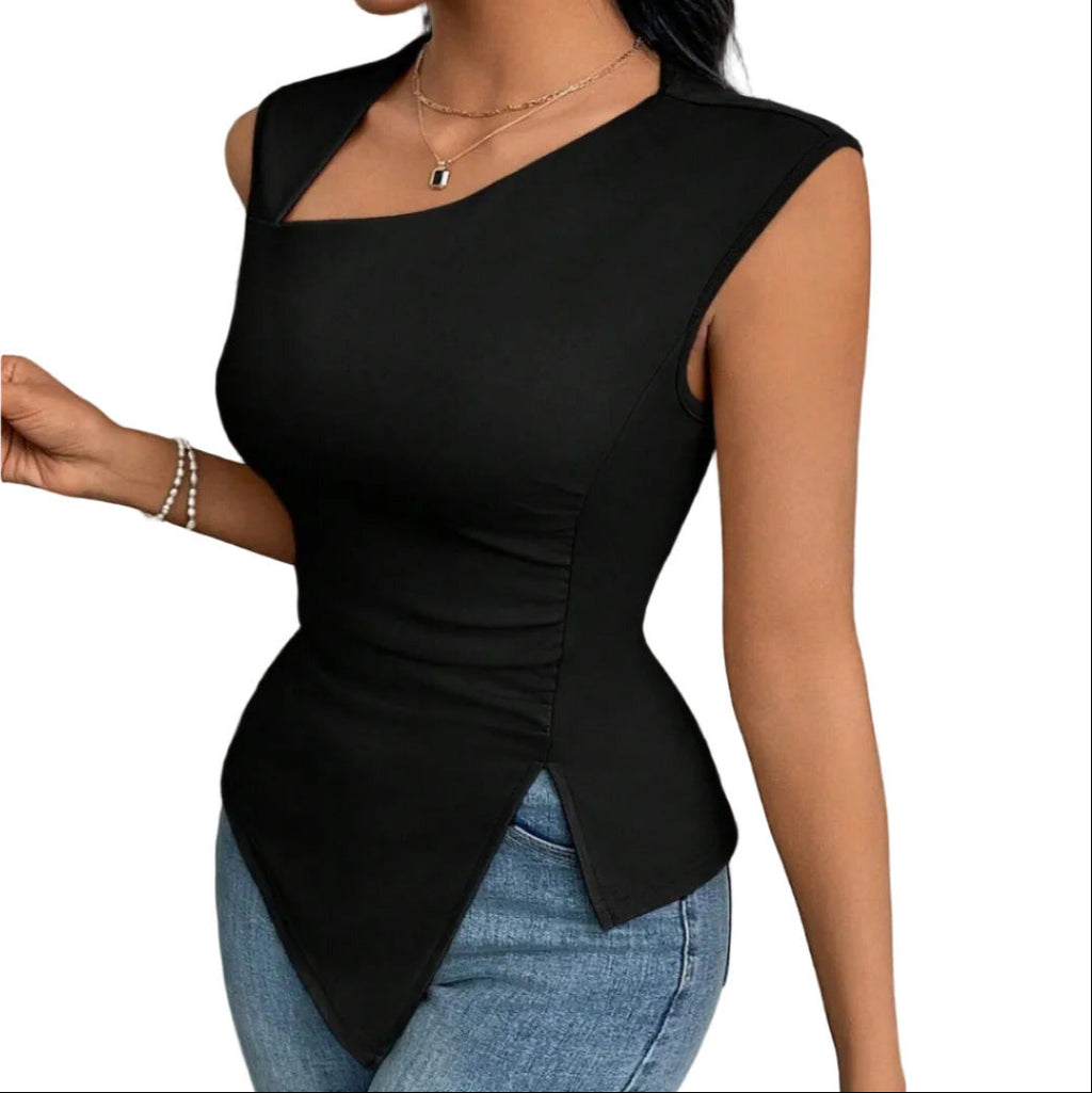 Person wearing a black sleeveless top and blue jeans against a textured white wall.