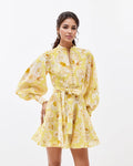 Woman in a yellow floral dress on white background
