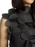 Black floral shoulder detail on a garment against a neutral background
