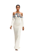 Model wearing a white off-shoulder dress with blue floral details
