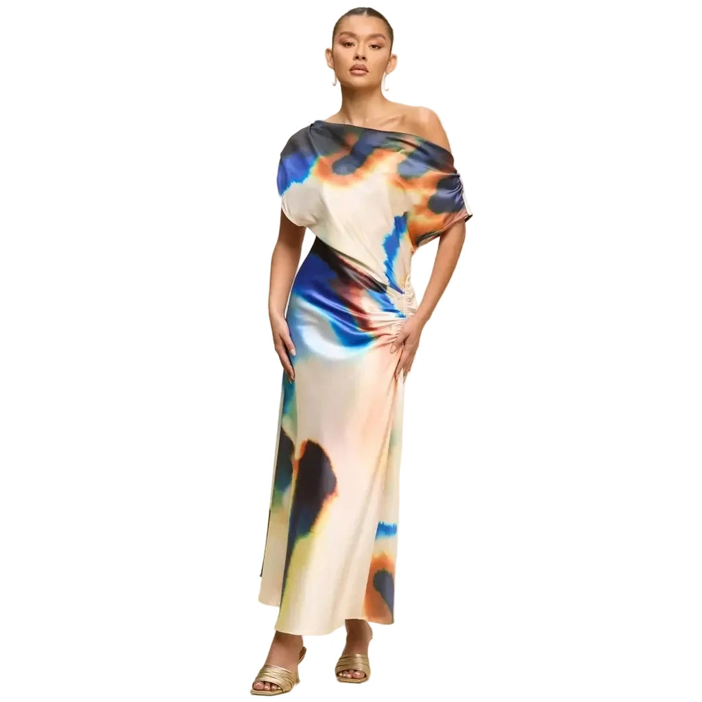 Woman wearing a colorful one-shoulder dress on a beige background